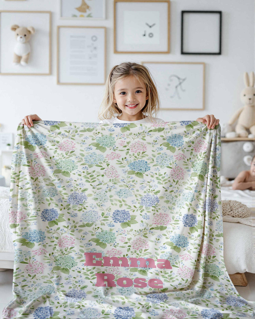 Girl holding up the preppy hydrangea blanket in her room