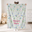 Child holding a pink and blue hydrangea blanket with Emma Rose