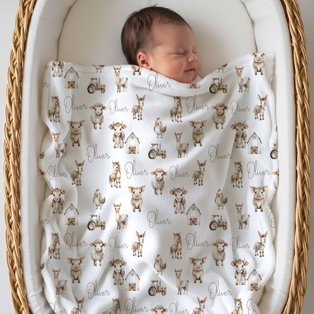 Newborn asleep under a farm animal name blanket in a bassinet