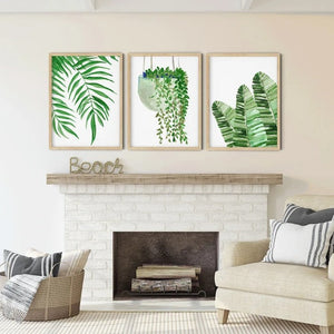 Palm, trailing pothos and banana leaf prints above a white fireplace